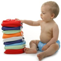 a baby and a stack of diapers