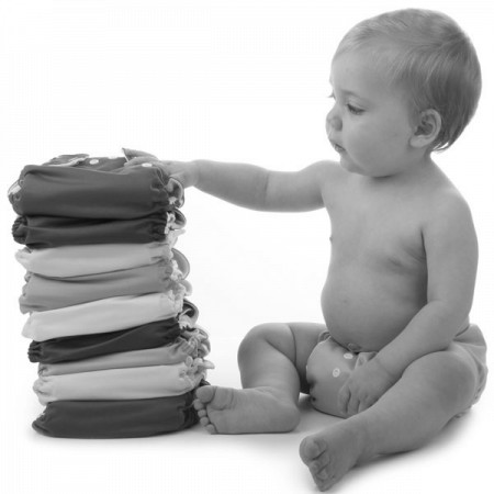a baby and a stack of diapers